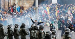 Colombian protesters advance through tear gas towards a police lline