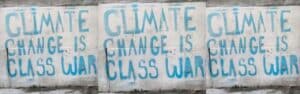 Climate Change Is Class War in clear three times in blue print on a white wall