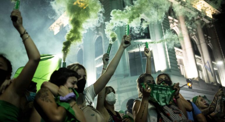 Argentinian Women with green pañuelos and green smoke from cannisterts held high protesting for abortion rights.