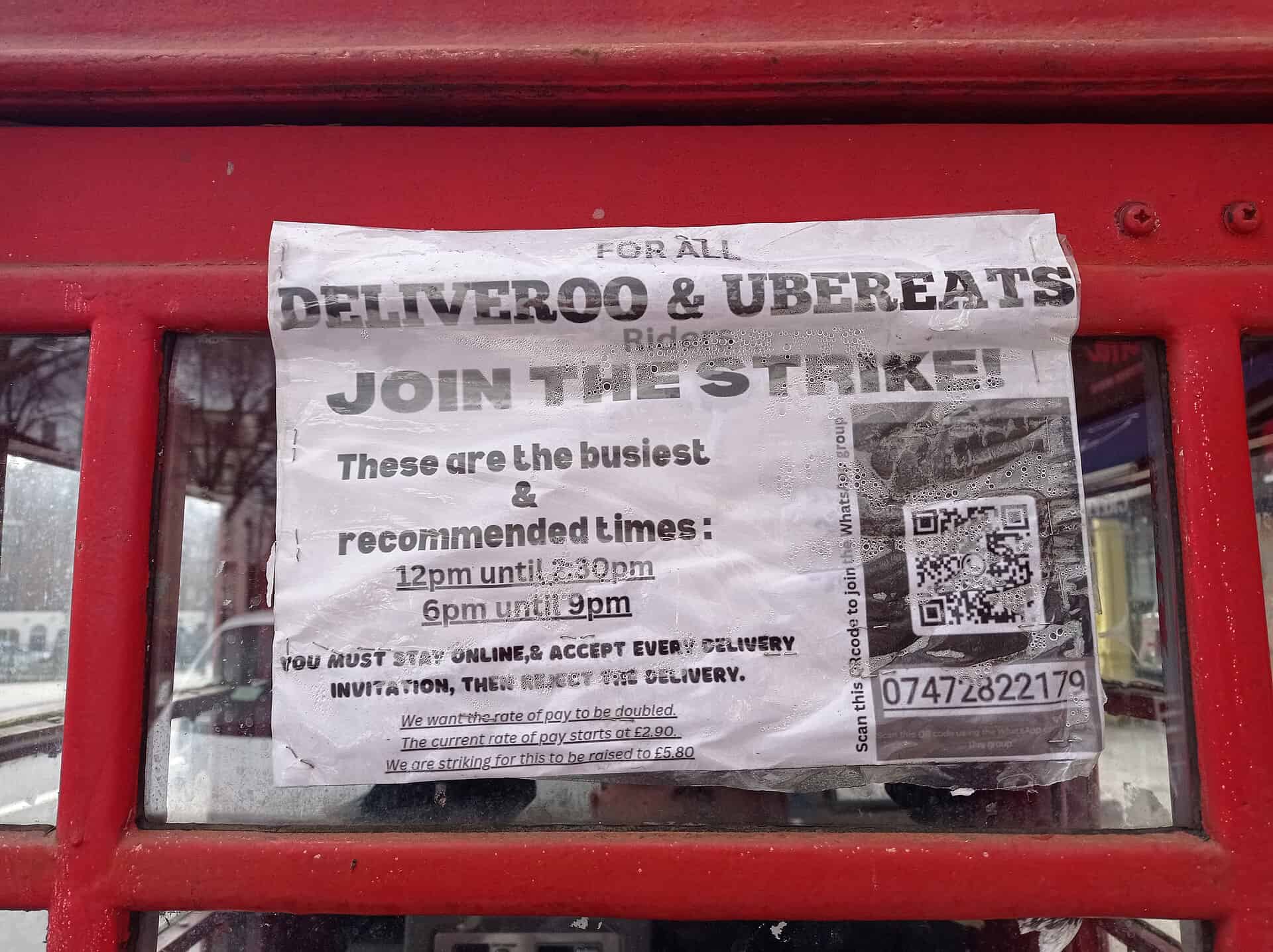 Notice on Islington phone box - Join the Deliveroo & Uber Eats strike. Feb 2024. Photo Credit: Philafrenzy via Wikimedia
