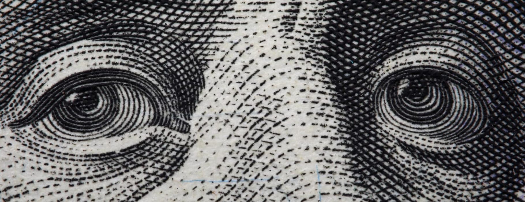 Close-up of Benjamin Franklin's face on hundred banknote.
