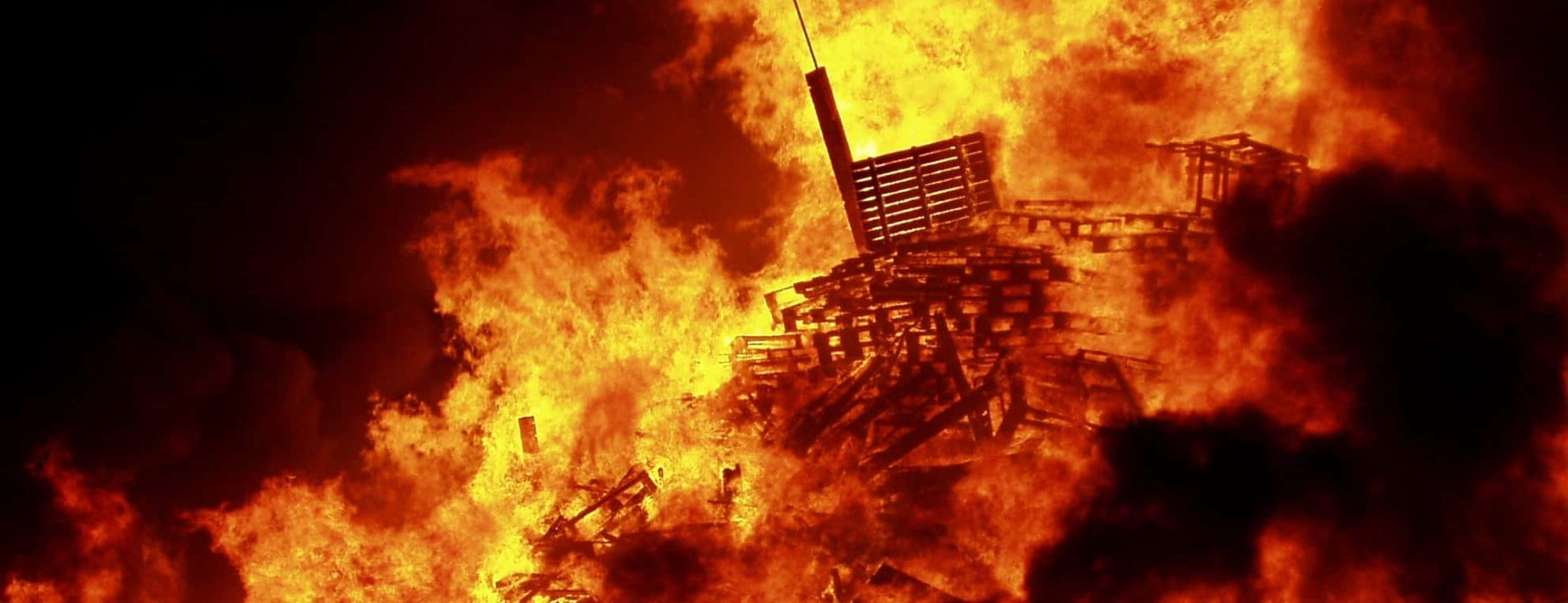 An Eleventh Night bonfire in Belfast, Northern Ireland is lit on fire as part of an Ulster Loyalist celebration. 2006. Photo Credit: Kindonnelly via wikimedia