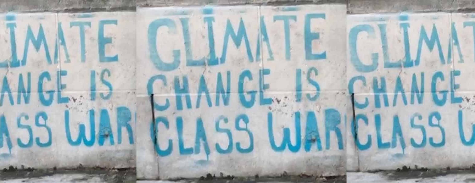 Climate Change Is Class War in clear three times in blue print on a white wall